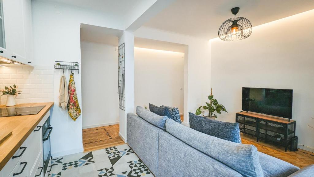 a living room with a couch and a tv at Apartejo River Tagus View in Póvoa de Santa Iria