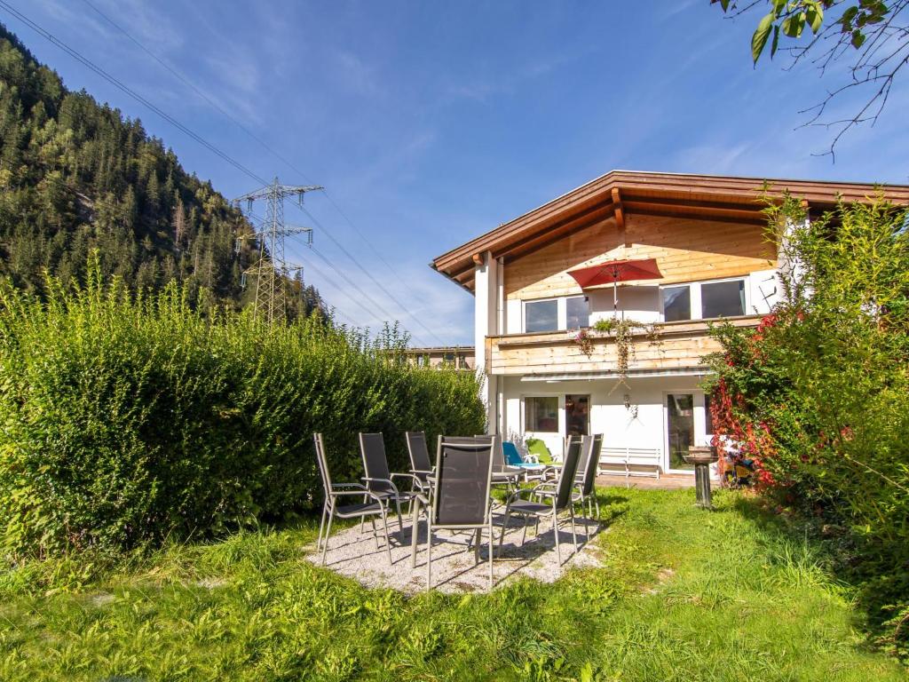 um grupo de cadeiras sentadas no pátio de uma casa em Regenbogenhaus em Mayrhofen