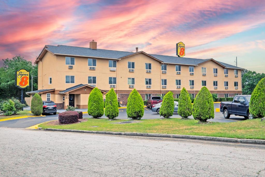 a hotel with cars parked in a parking lot at Super 8 by Wyndham Augusta Ft Eisenhower Area in Augusta