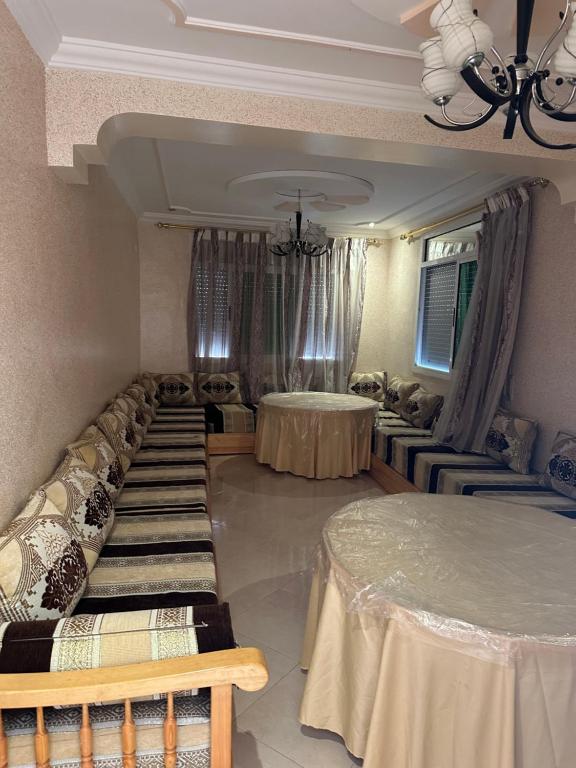una habitación con filas de camas y mesas en Rafi Apartments al Hoceima, en Alhucemas