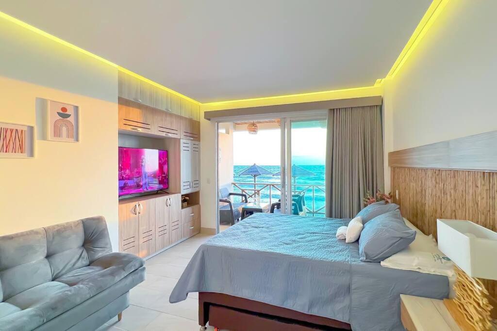 Suite privada frente al mar. في San Silvestre: غرفة نوم بسرير واريكة وتلفزيون