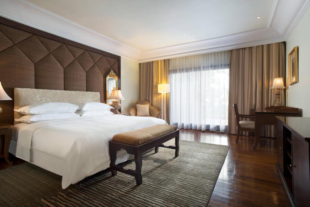 a bedroom with a large bed and a large window at Sheraton Senggigi Beach Resort in Senggigi