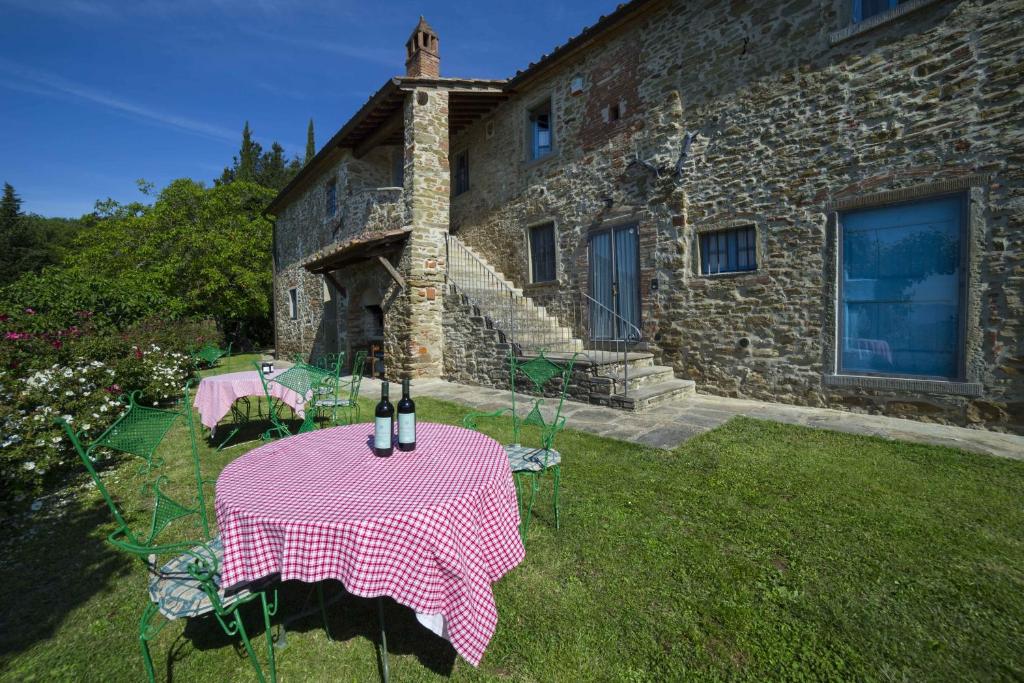 uma mesa em frente a uma casa de pedra com uma toalha de mesa rosa em Forte Di Tregognano em Subbiano