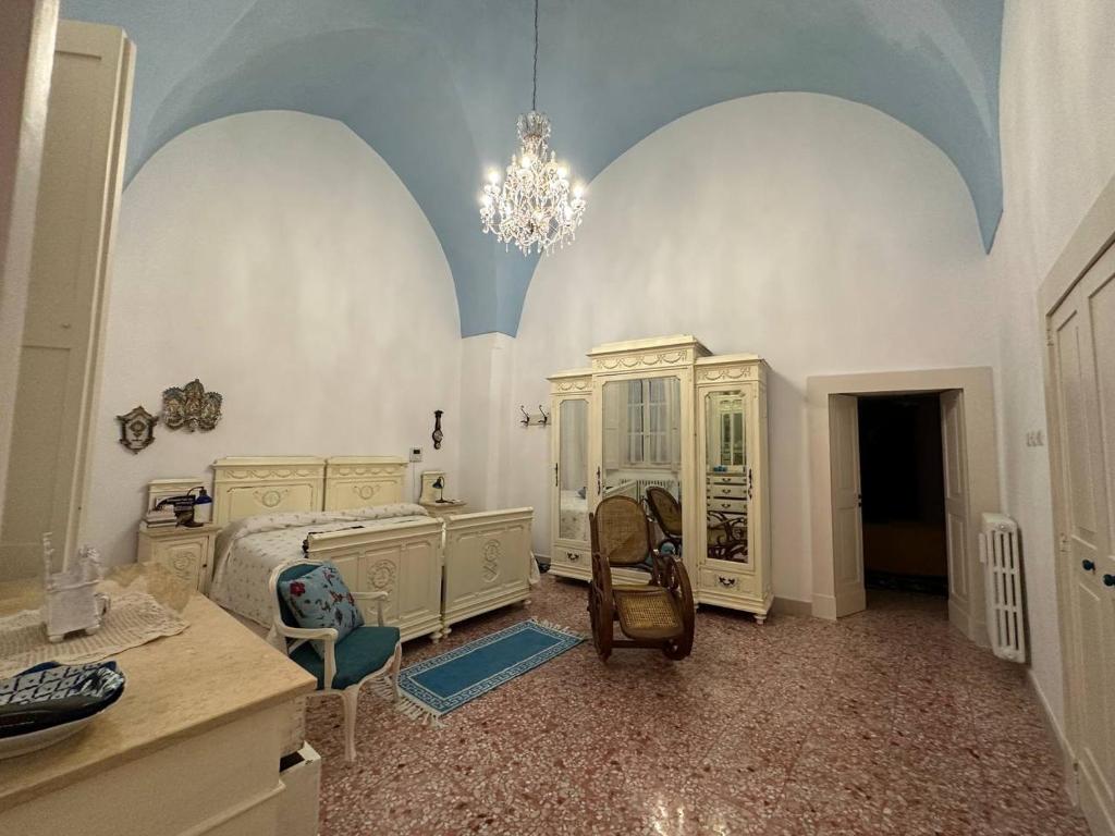ein Schlafzimmer mit weißen Möbeln und einem Kronleuchter in der Unterkunft Casa Vacanze Gallipoli in Gallipoli