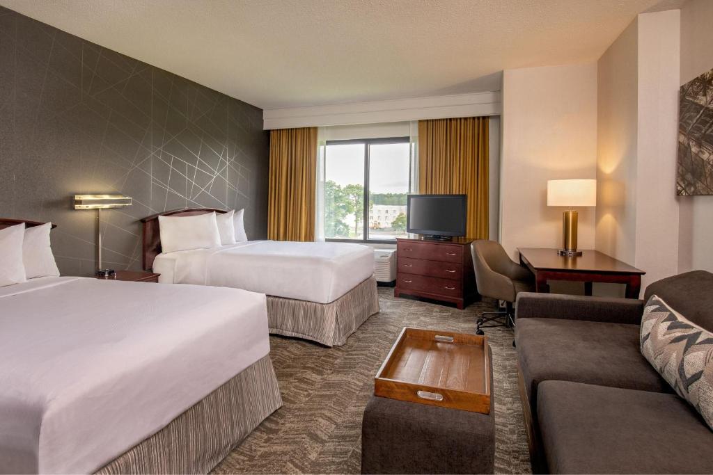 a hotel room with two beds and a couch at SpringHill Suites by Marriott Norfolk Virginia Beach in Virginia Beach