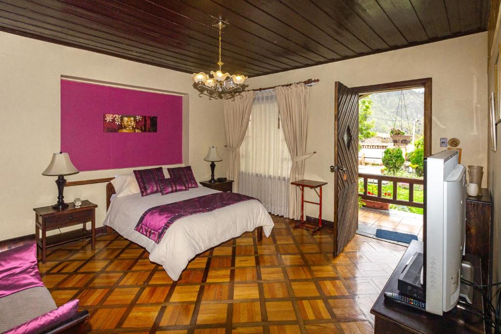 een slaapkamer met een bed en een roze muur bij QUINTA LOREN HOSTERIA in Ambato