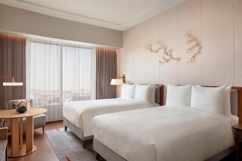 a hotel room with two beds and a window at JW Marriott Hotel Nara in Nara