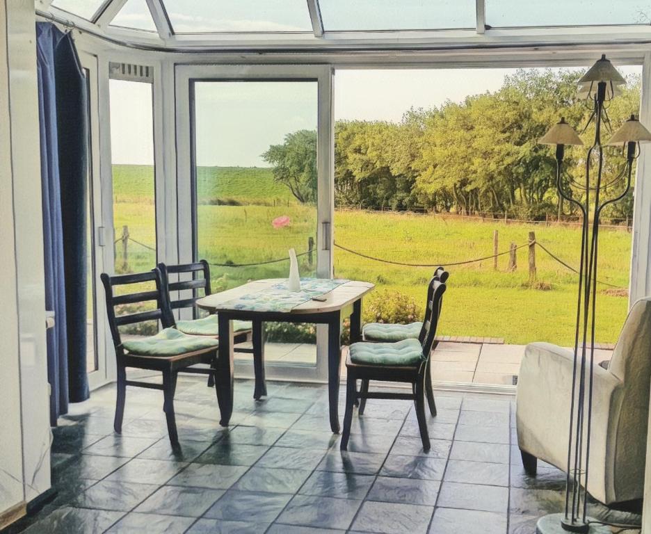 Un comedor con mesa y sillas y una ventana. en Fregatte Wintergarten, en Wangerooge