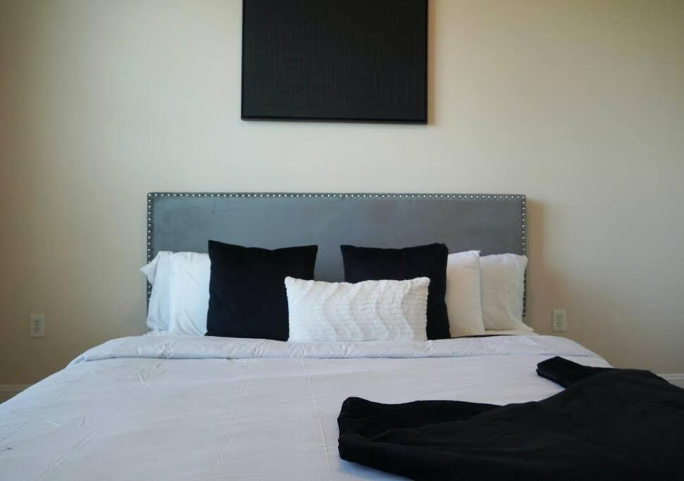 a bedroom with a white bed with black and white pillows at New Apartment in Houston in Houston