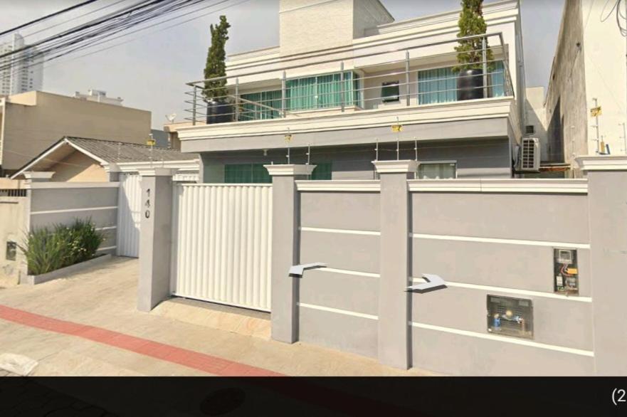 uma casa com uma porta de garagem branca e um edifício em Casa em Itajaí Balneário Camboriú e Parque Beto Carrero em Itajaí