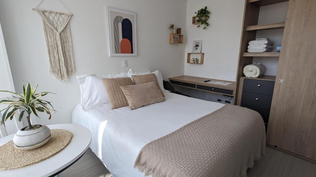 een slaapkamer met een wit bed en een tafel bij Espectacular Aparta-Estudio en Chapinero Central in Bogota