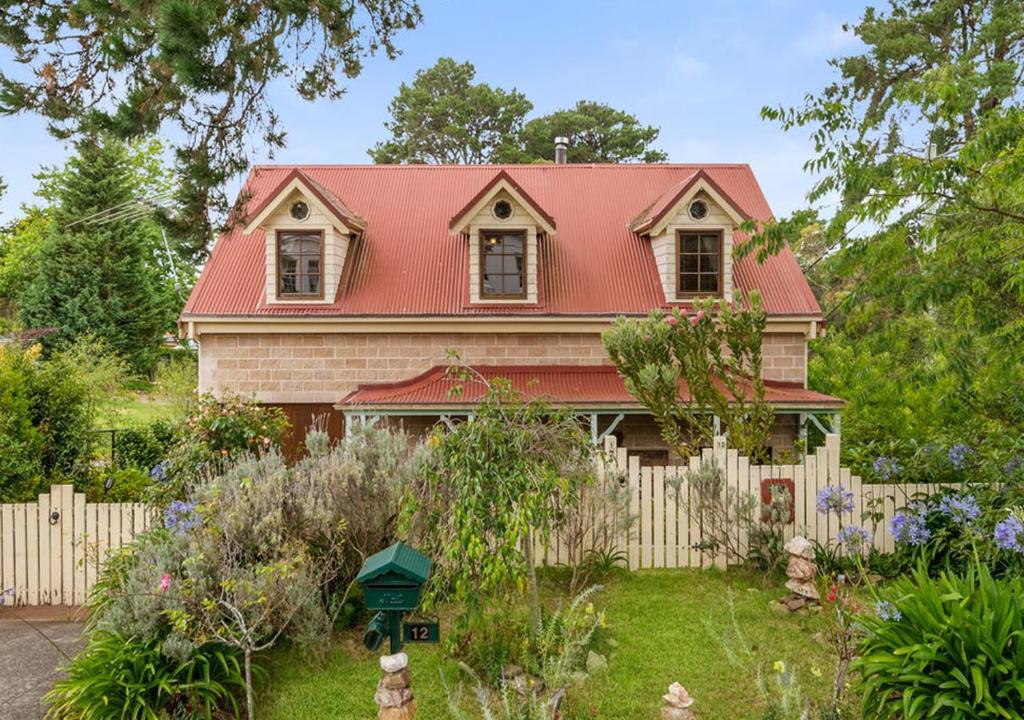 ein Haus mit rotem Dach und einem Zaun in der Unterkunft Blue Country Lodge in Katoomba