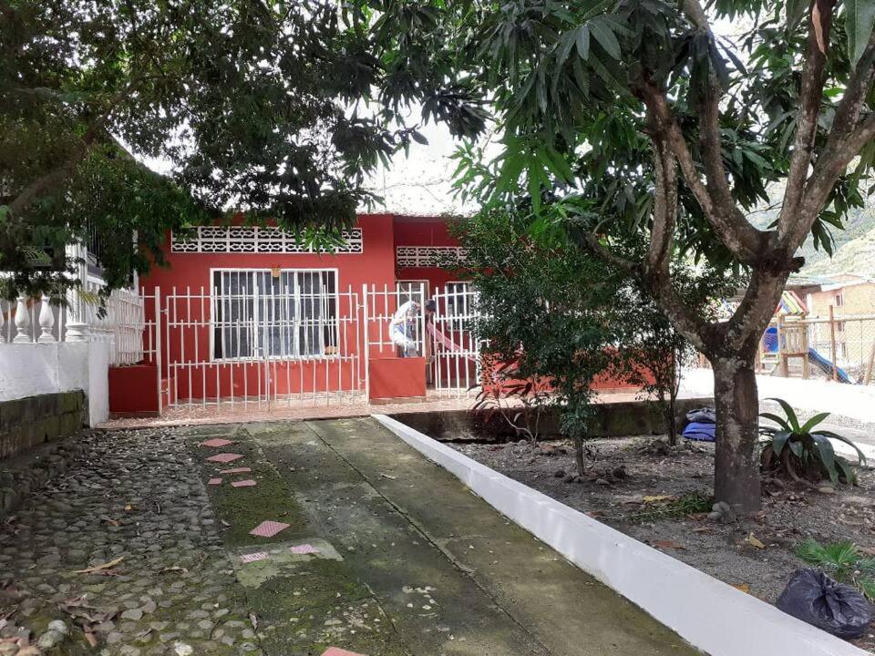 una casa roja con una puerta roja y un árbol en Hospedaje casa completa Honda Tolima, en Honda