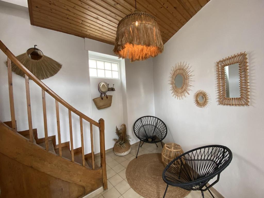 a room with a staircase with chairs and a mirror at Appartement cosy à Fouras: 1 chambre, proche commerces et plages, Wifi, TV, cuisine équipée - FR-1-709-70 in Fouras
