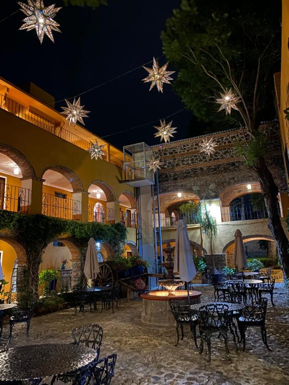 un patio con mesas y sillas por la noche en Hotel Hacienda Monteverde San Miguel de Allende, en San Miguel de Allende