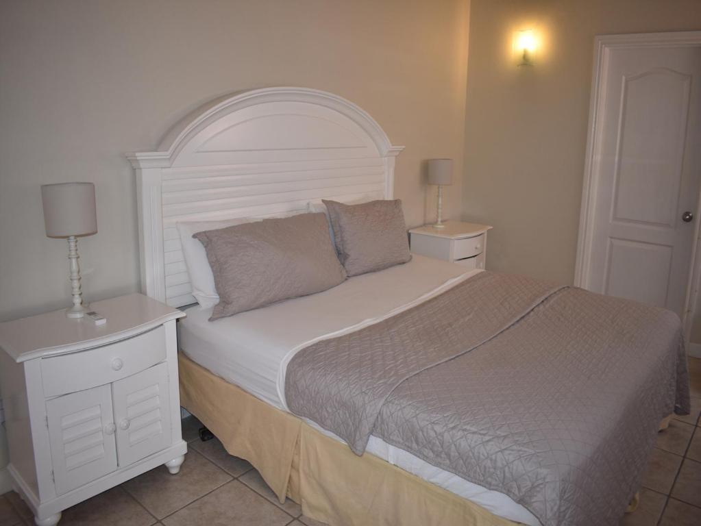 una camera con un grande letto con testiera bianca di Harbour View Penthouse a Gros Islet