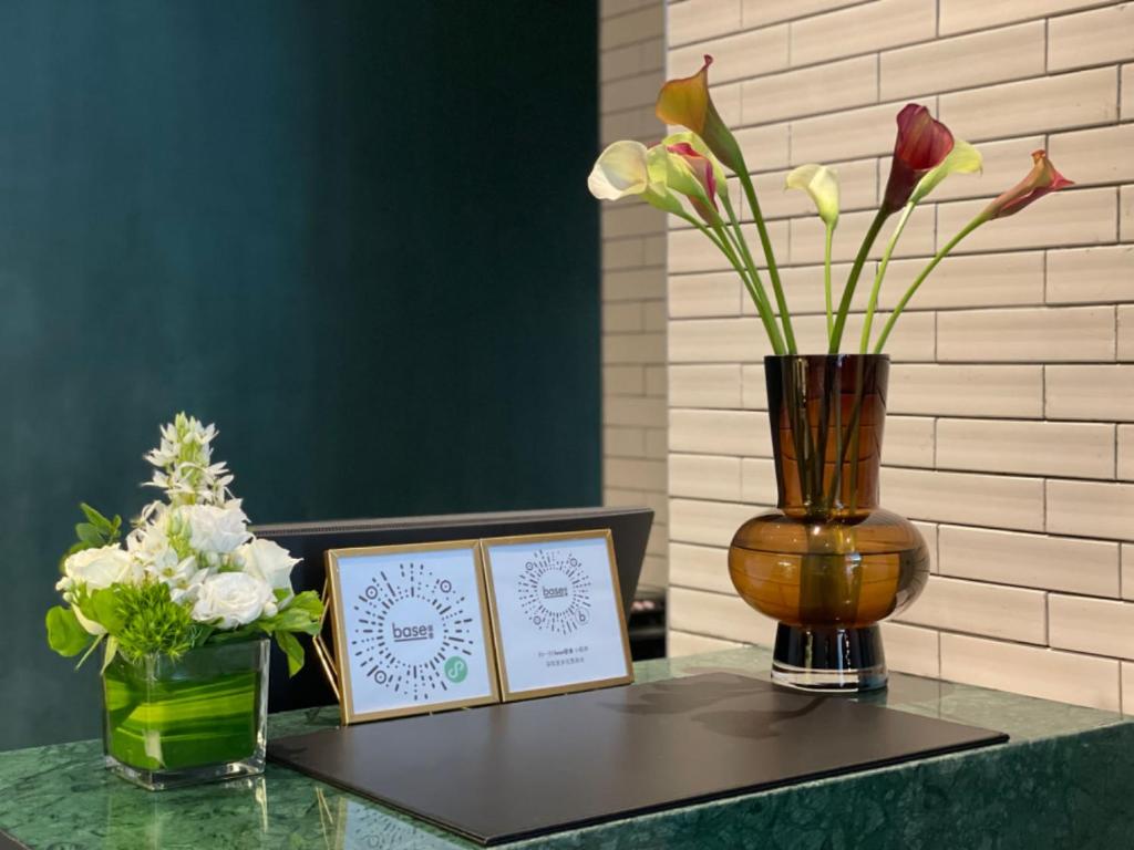 a table with a vase and two cards and flowers at base-Beijing Wangfujing Serviced Apartment- in Hutong &Bike rental &Close to Forbidden City, Tian'anmen Square &Subway nearby &Free coffee &Washing machine,Kitchen &Restaurant discount &English speaking &High speed free WiFi in Beijing