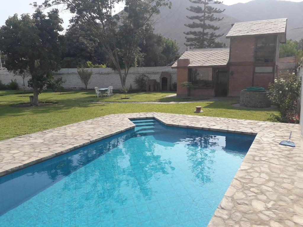 謝內吉亞區的住宿－Casa de campo en Cieneguilla con Piscina，一座带房子的庭院内的游泳池