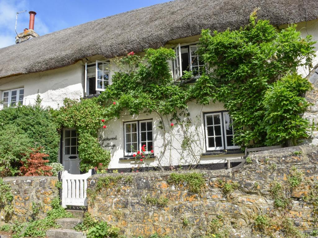 an old stone house with a thatched roof at Rookwood in Exeter