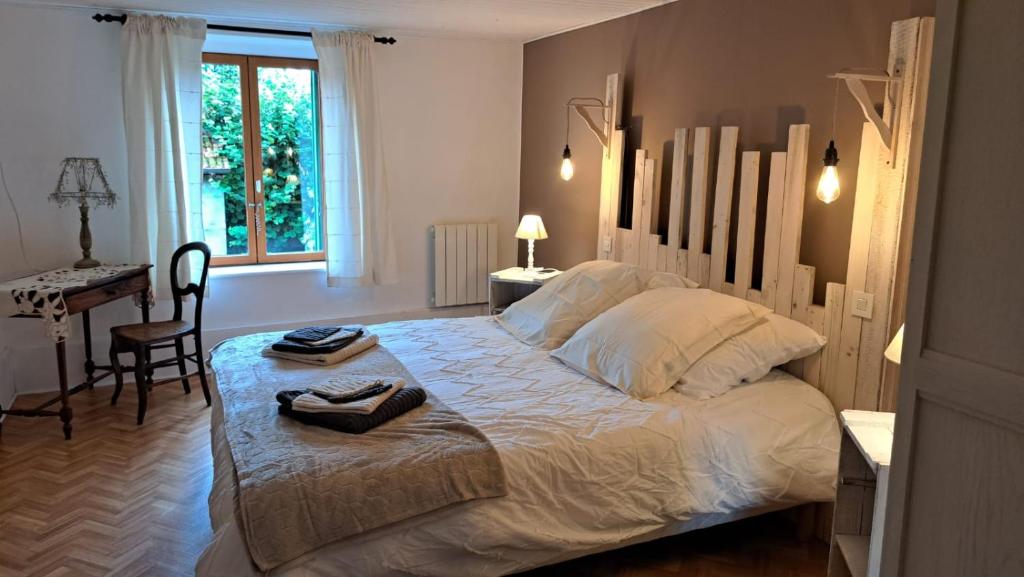 - une chambre avec un grand lit blanc et un bureau dans l'établissement L'Atout Charme, à Bains-les-Bains