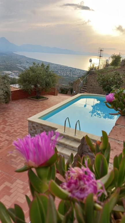 - une vue sur la piscine ornée de fleurs violettes dans l'établissement Villa Verde, à Cefalù