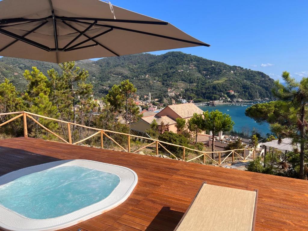 einen Whirlpool auf einer Holzterrasse mit einem Sonnenschirm in der Unterkunft La Madonetta - Dimora d'epoca - in Levanto