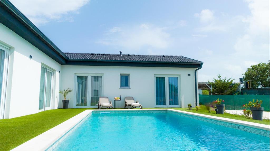 uma piscina com duas cadeiras ao lado de uma casa em Villa Corona Cordis em Banjole