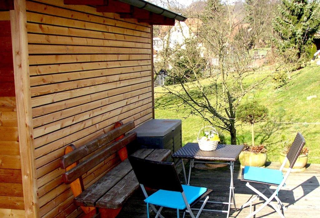 eine Terrasse mit einem Tisch und Stühlen neben einem Gebäude in der Unterkunft Ferienwohnung Makowitschka in Kreischa