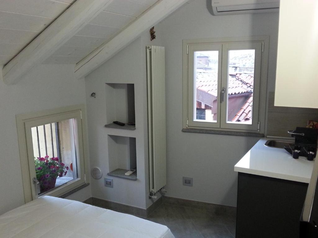 a white room with a sink and two windows at Mansarda Palatina in Turin