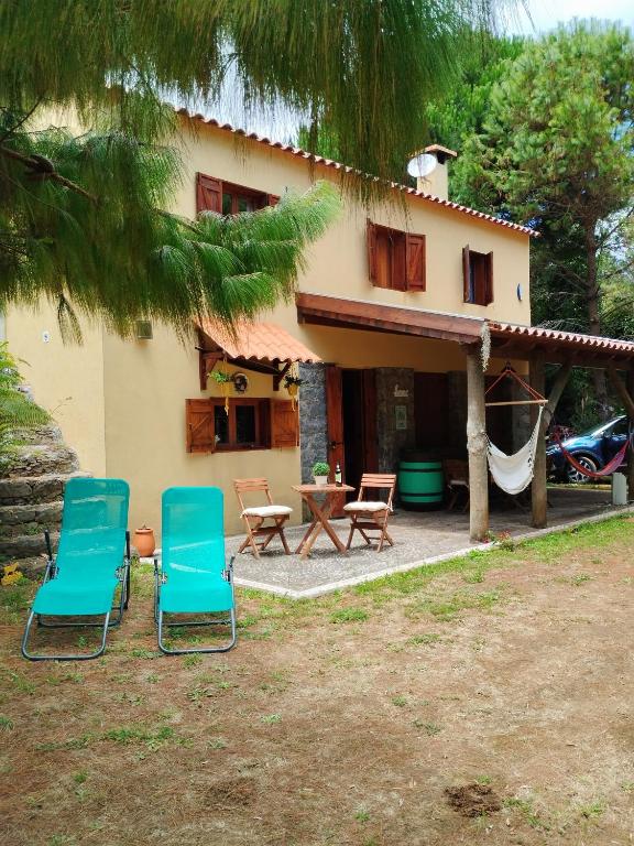 two chairs and a table in front of a house at Quinta Meneses in Santa Cruz