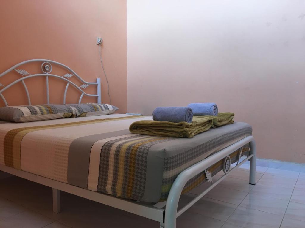 Una cama con dos toallas encima. en Homestay Abdul, en Kampung Banggul Gucil