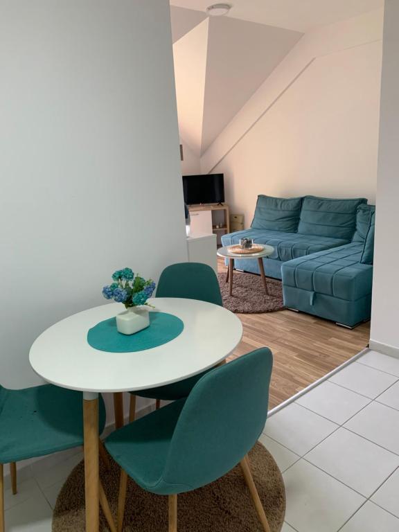 un soggiorno con tavolo, sedie e divano di Filip Apartment a Mavrovo