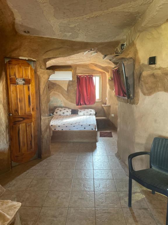 Habitación con 2 camas y TV en una cueva en המערה הפוריה בפוריה, en Poriyya