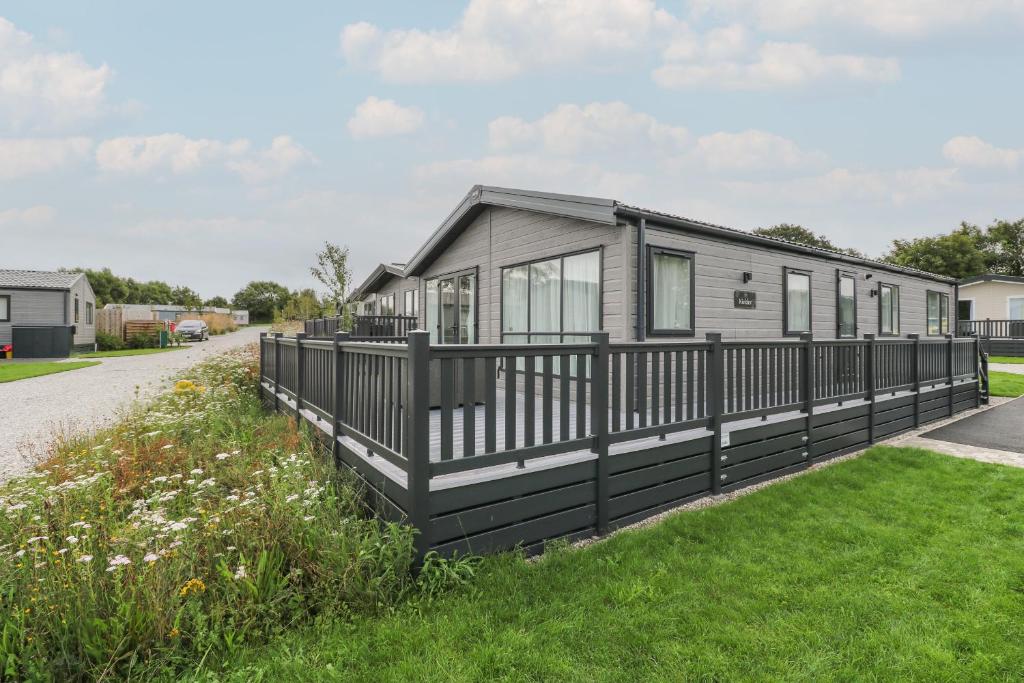 a modular home with a black fence at Penmarlam Lodge Retreat 12 in Fowey