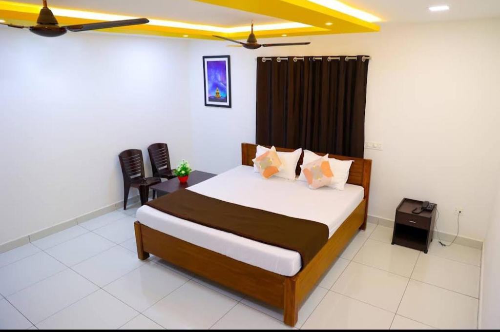 a bedroom with a bed and a chair in it at Paradise Golden Residency in Kottakupam
