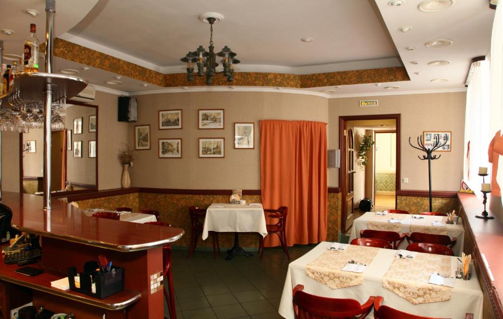 a dining room with two tables and chairs in a restaurant at Atlantik Hotel in Vyborg