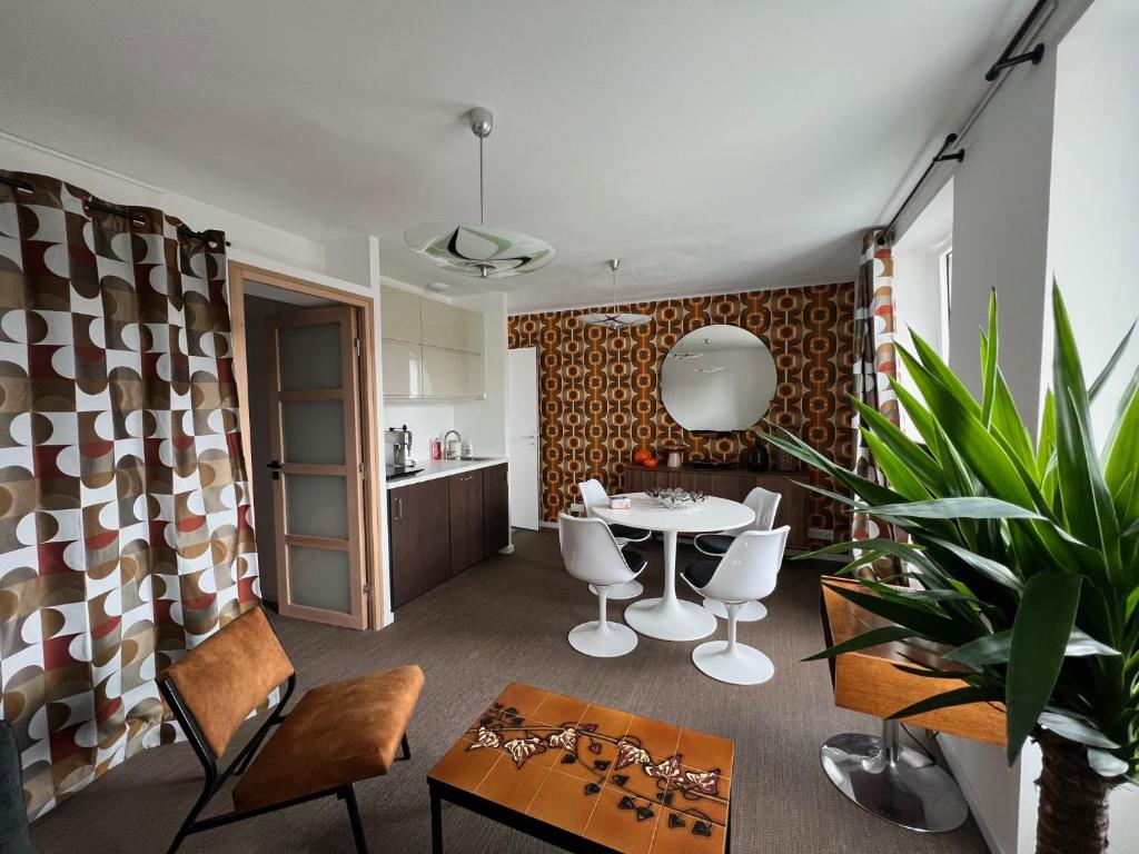 Appartement - Galerie POP ART - Trentemoult في ريزي: مطبخ وغرفة معيشة مع طاولة وكراسي