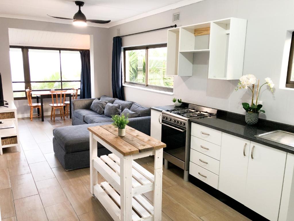 a kitchen and living room with a couch and a table at 90 Eden Sands 2 Bedroom Flat with Beach Access in Kingsburgh