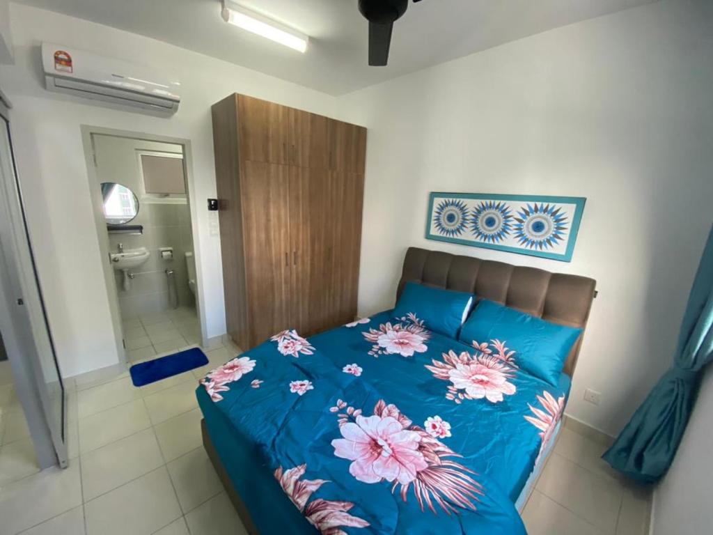 Un dormitorio con una cama azul con flores. en KLIA KLIA2 Alanis Sepang Putrajaya Cyberjaya Nilai by 3SIBS en Sepang
