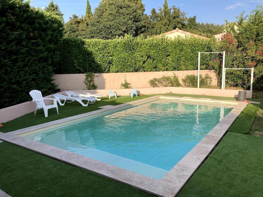 a swimming pool in a garden with a lawn at Appartement in Montélimar