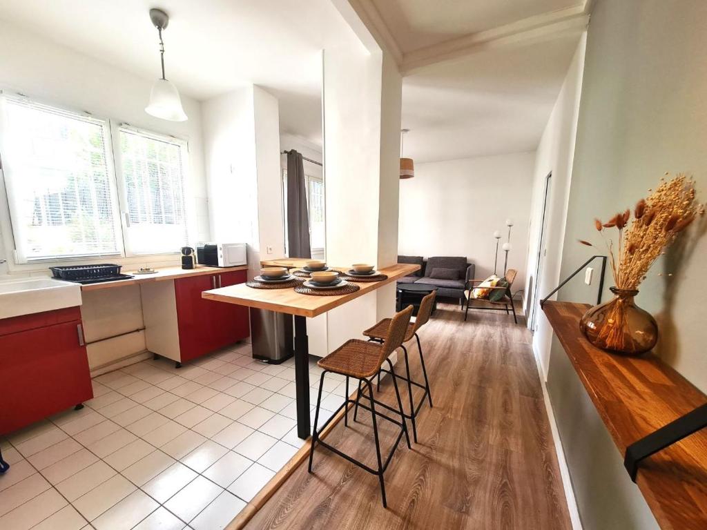塞納河畔伊夫里的住宿－Appartement F3 55m2 à 5' de Paris，厨房以及带桌椅的起居室。