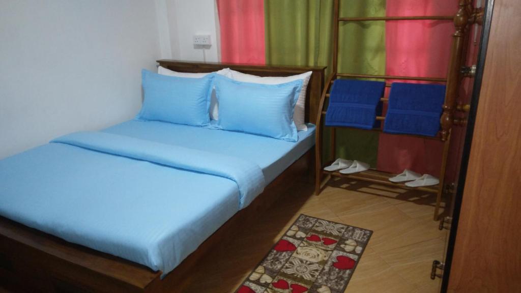 a bedroom with two beds and blue pillows at ANTONIO TRANSIT KATUNAYAKE in Katunayaka