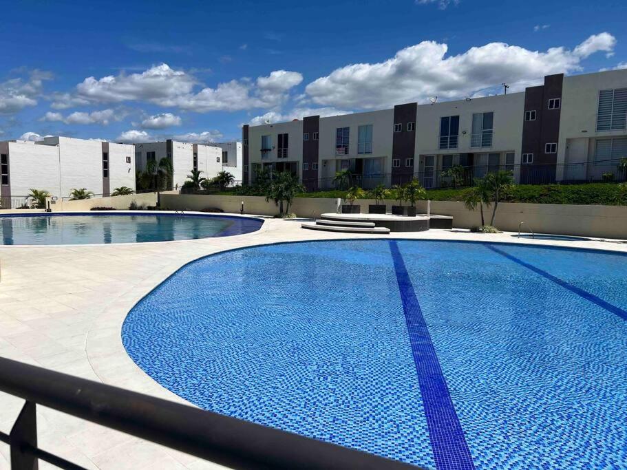 una gran piscina frente a un edificio en Bellísima casa para descansar, en Ricaurte