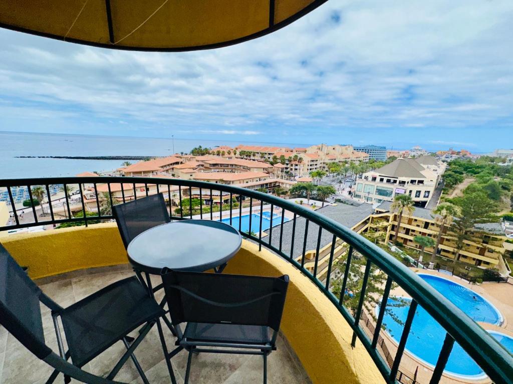 a balcony with two chairs and a table and the ocean at Torres del Sol Playa de Las Vistas FREE WIFI in Playa de las Americas