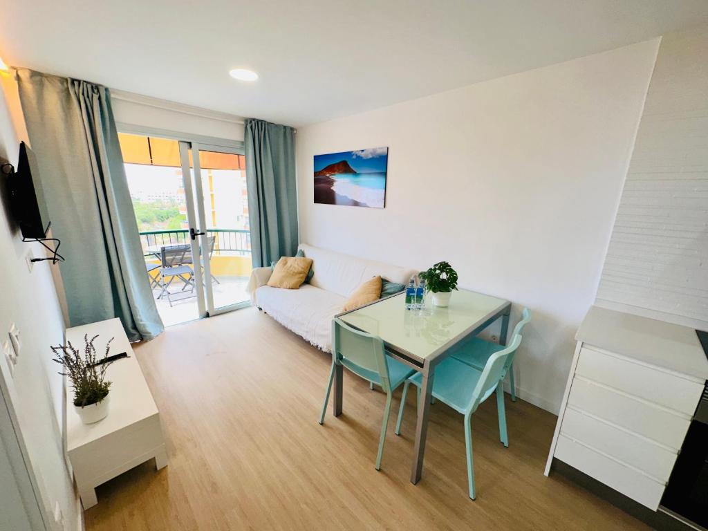 a living room with a table and a couch at Torres del Sol Playa de Las Vistas FREE WIFI in Playa de las Americas