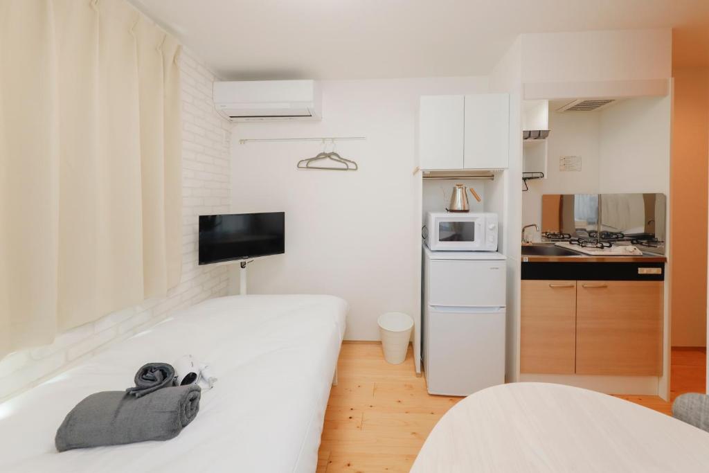 a small room with a bed and a kitchen at Nakano Five in Tokyo