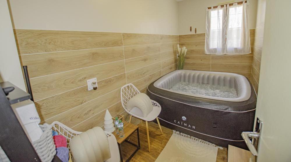 - une grande baignoire dans une chambre avec une table et des chaises dans l'établissement Maison des 3 lacs, à Chavanges