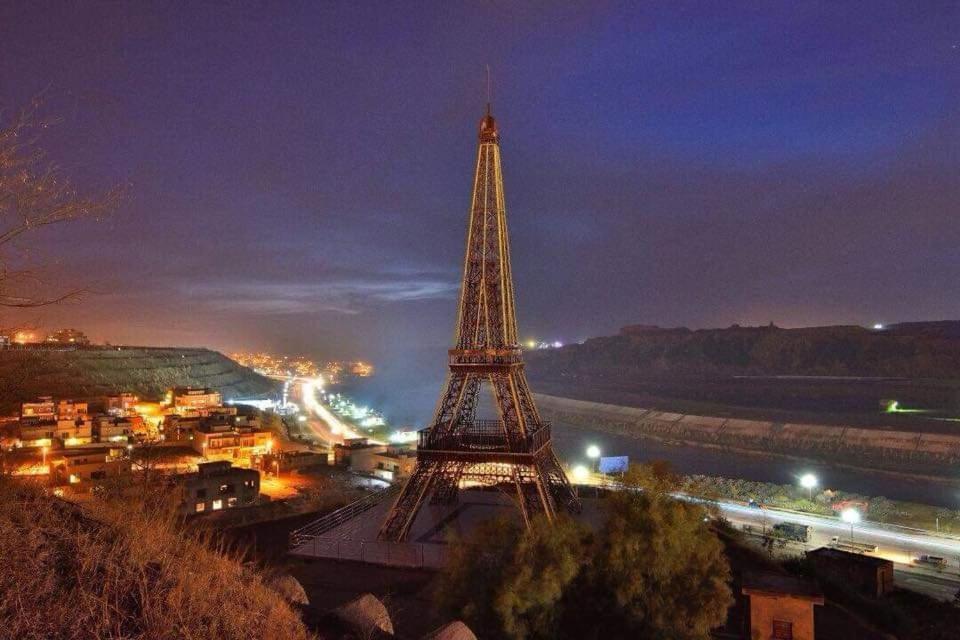 a view of the eiffel tower at night at Eiffel Tower Apartment in Rawalpindi