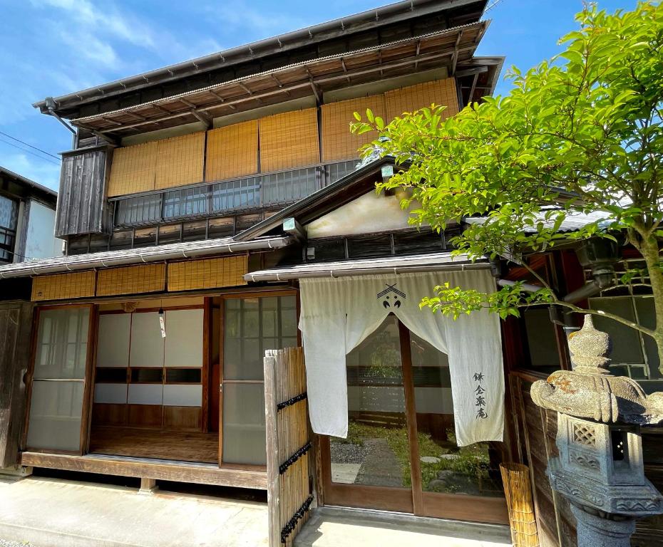 un edificio con una cortina delante de él en 古民家の宿 鎌倉楽庵, en Kamakura