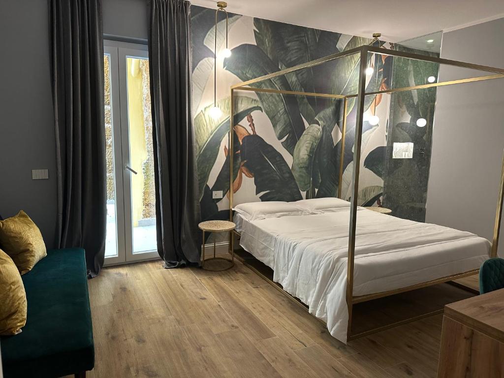 a bedroom with a canopy bed with a painting on the wall at Krysos Luxury Rooms in Agrigento